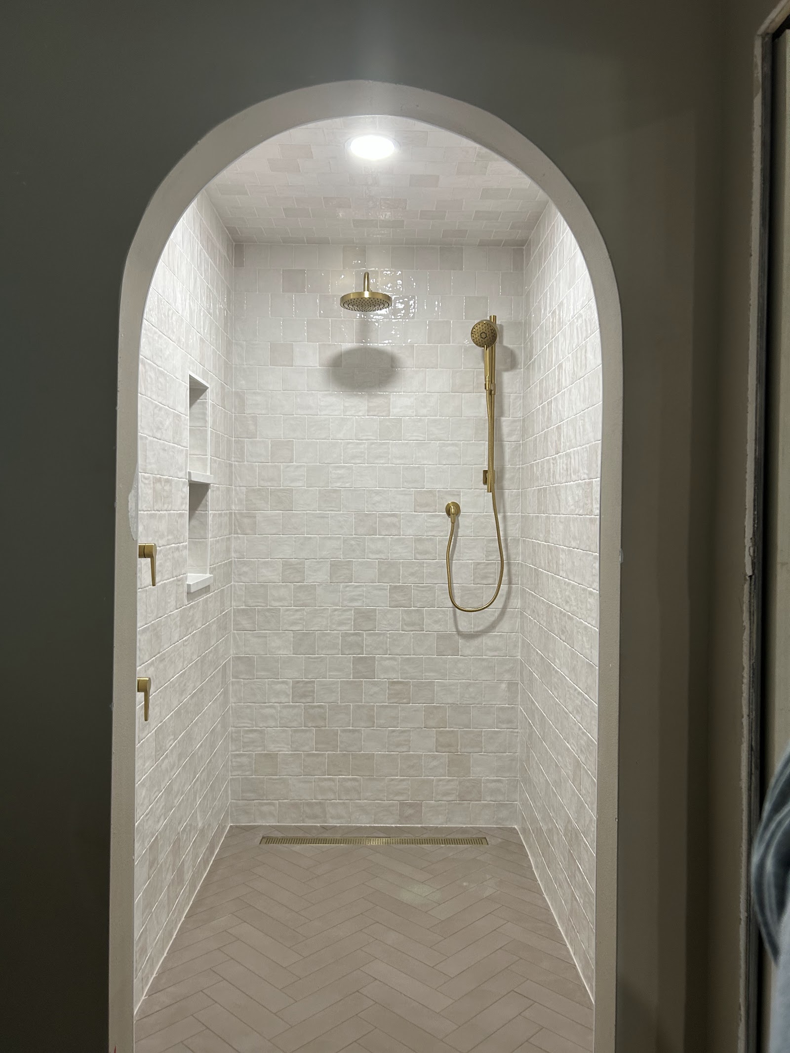 Arched walk-in shower and herringbone floor by 321 Tile